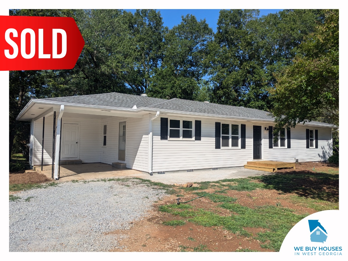 A ranch-style house with white siding, black trim, and a carport, bought by We Buy Houses in West Georgia